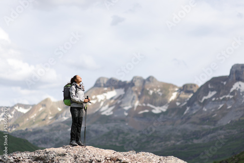 Full body of a hiker breathing fresh air in a high mountain