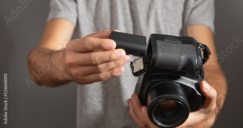 Photographer inserting battery to the camera. © andranik123