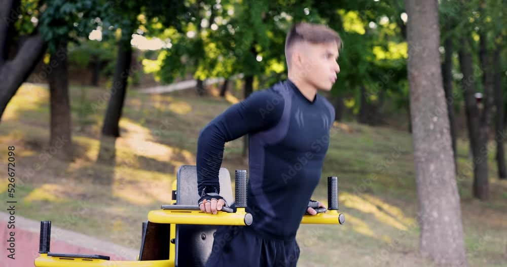 Muscular man trains Up In Public Gym. Healthy Man On Pull-up Bars Exercising Muscular man trains Up In Public Gym. Healthy Man On Pull-up Bars Exercising