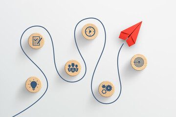 Red paper plane and wooden cubes with business strategy icons on white background