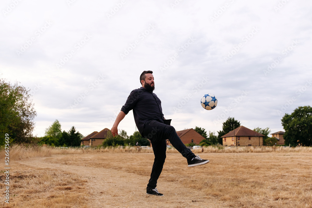 Mature man playing with soccer ball in field Mature man playing with soccer ball in field