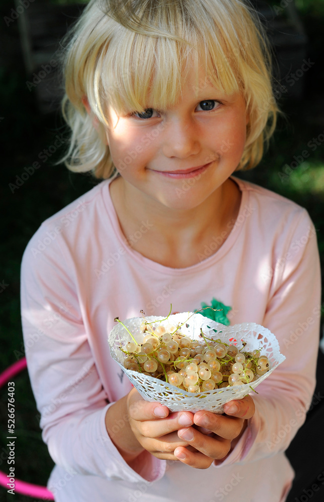 Portrait of a little girl holding freshly picked currants Portrait of a little girl holding freshly picked currants