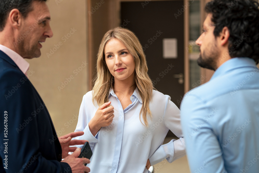 Mature businessman discussing strategy with colleagues in corridor Mature businessman discussing strategy with colleagues in corridor