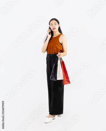 Asian woman calling and shopping on white screen background, full body standing.