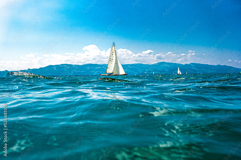 Segelboot auf dem Bodensee, entspannte, gelassene Sommerstimmung mit Wellen, und blauen Himmel - obrazy, fototapety, plakaty 