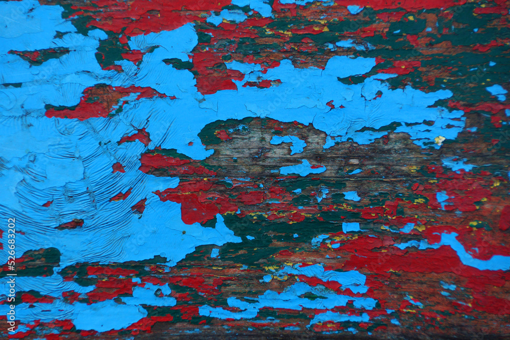 Wooden board with worn blue and red paint.