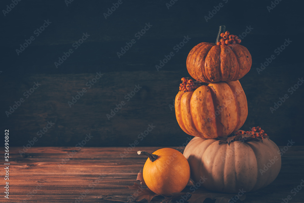 Rustic autumn still life with pumpkins and golden leaves on a wooden surface