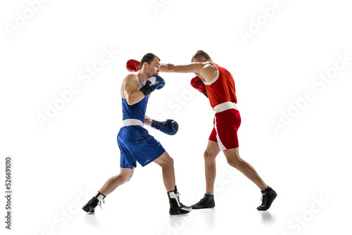 Dynamic portrait of two professional boxer in sports uniform boxing isolated on white background. Concept of sport, competition, training, energy © master1305
