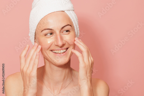 Fototapete Woman with patches under her eyes touching her smooth skin