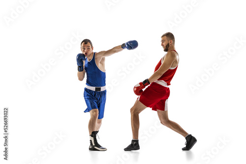 Dynamic portrait of two professional boxer in sports uniform boxing isolated on white background. Concept of sport, competition, training, energy