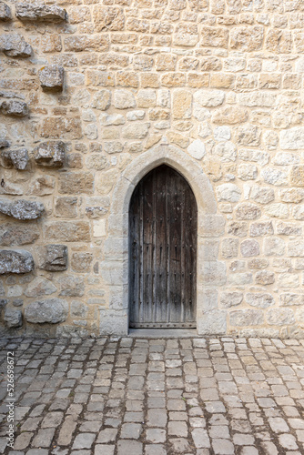 medieval castle wooden door, stone wall and cobbled floor, verical format © © Raymond Orton