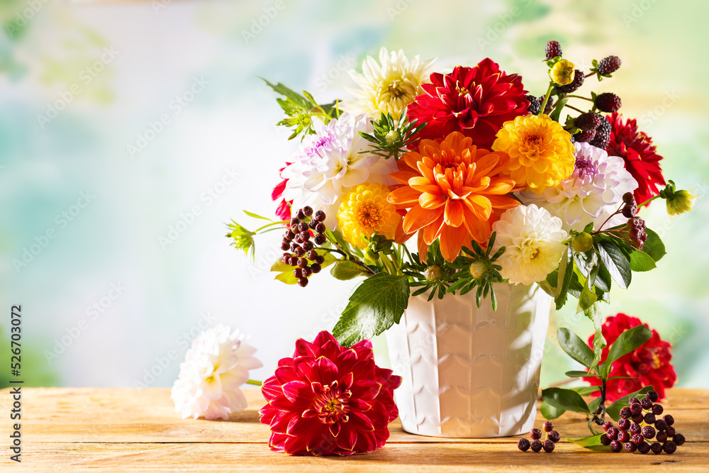Autumn still life with garden flowers. Beautiful autumnal bouquet in vase on wooden table. Colorful dahlia, chrysanthemum and berries. Autumn still life with garden flowers. Beautiful autumnal bouquet in vase on wooden table. Colorful dahlia, chrysanthemum and berries.