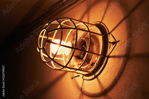 Old electric light bulb with a metal cap on the wall © DAndreev