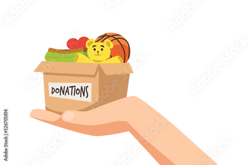 Hand holding donation paper box with toys and clothes, flat vector illustration isolated on white background.