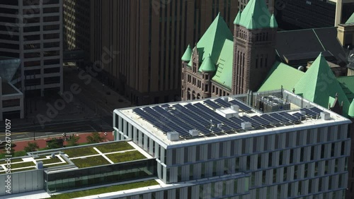 Solar panels on building rooftop in downtown Minneapolis, City Hall in backgeround photo
