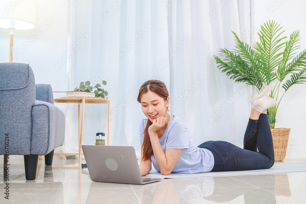 Young Asian healthy woman exercising with laptop at home Young Asian healthy woman exercising with laptop at home