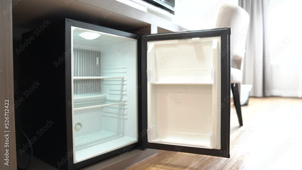 Refrigerator fridge mini size under the table counter with wooden desk beside it in hotel delux room. Refrigerator fridge mini size under the table counter with wooden desk beside it in hotel delux room.