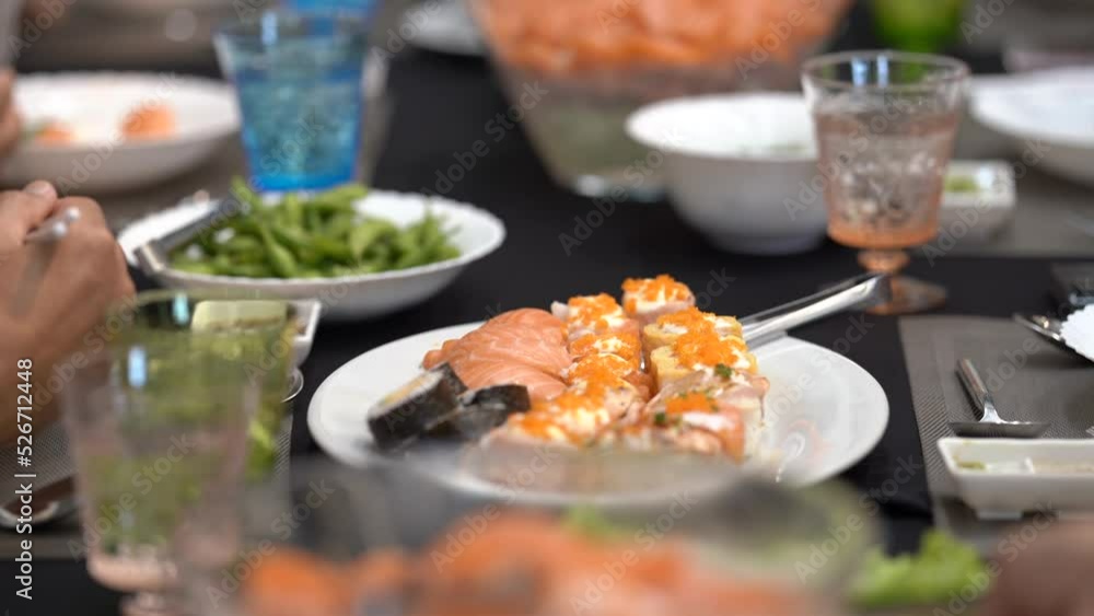 Salaryman is consuming a Japanese course at the high end restaurant, which is served with salmon, sushi, sashimi, and edamame on the large dining table. Salaryman is consuming a Japanese course at the high end restaurant, which is served with salmon, sushi, sashimi, and edamame on the large dining table.