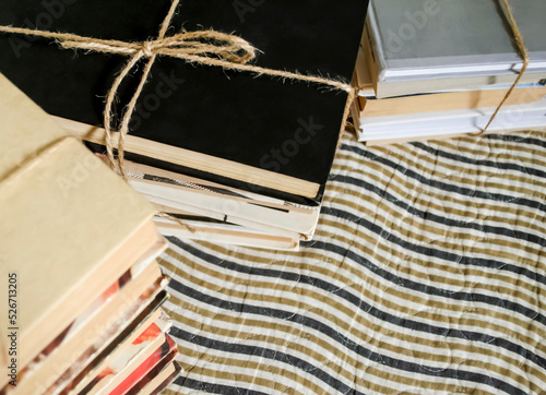 Obraz na plátne Stacks of books tied with whipping on a striped carpet