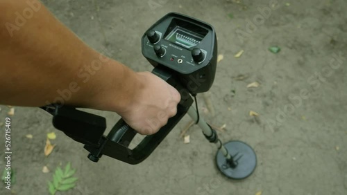 close up of a  right hand holding a metal detector photo