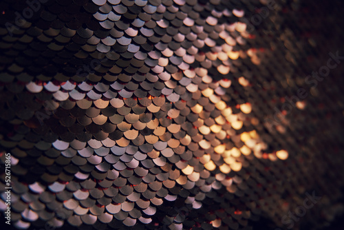 Glamorous background of multi-colored sequins, sequins. Sequins on the fabric, selective selective soft focus. Sequins shimmer in the sun