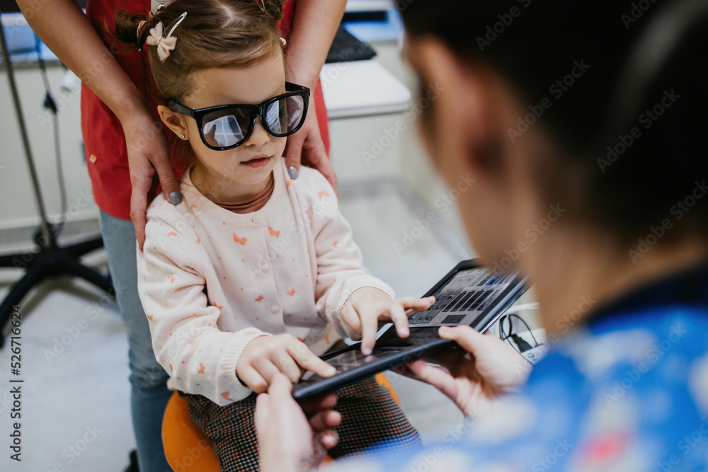 Beautiful and adorable little girl receiving ophthalmology treatment