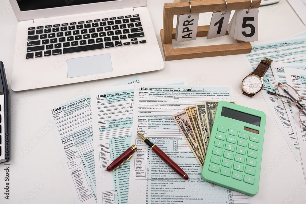 Obraz premium Blank personal income tax return with dollar bills and calculator and pen on calendar