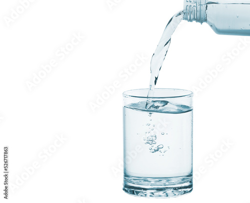 Pouring water into glass isolated on white background. Healthy drink concept. photo