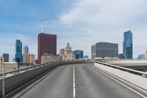 Empty urban asphalt road exterior with city buildings background. New modern highway concrete construction. Concept of way to success. Transportation logistic industry fast delivery. Chicago. USA.