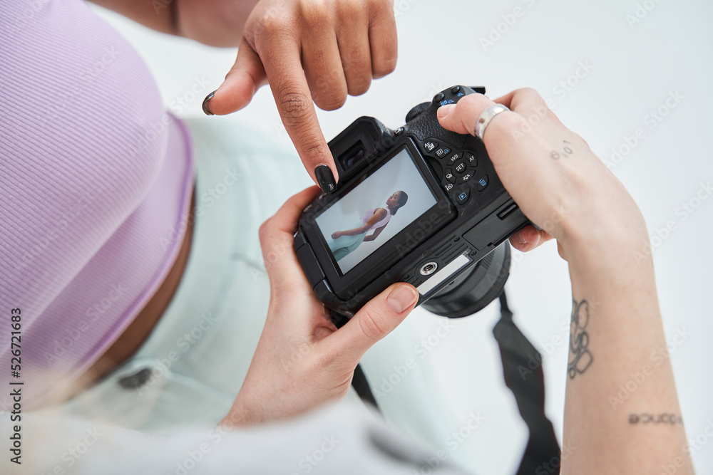 Model pointing with the finger at the camera screen while looking at the result of the photo session Model pointing with the finger at the camera screen while looking at the result of the photo session