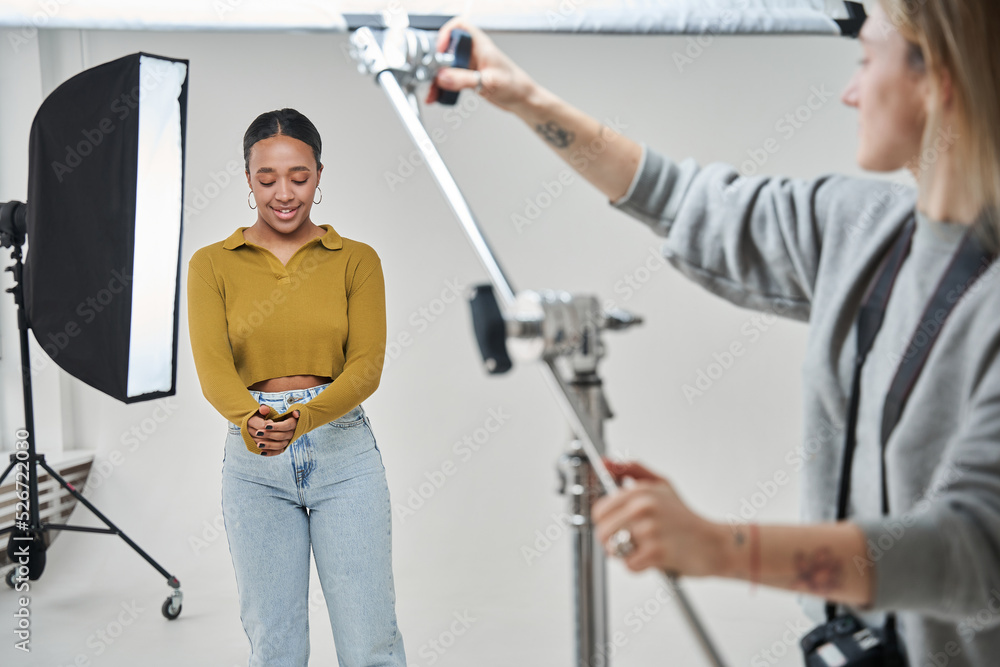 Female professional putting soft box at the right place and directing light at the model Female professional putting soft box at the right place and directing light at the model
