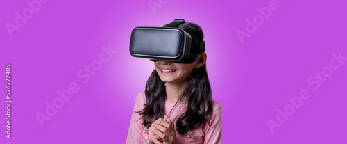 VR glasses , little girl with virtual reality headset. Innovation technology and education concept. Funny girl using a virtual reality headset isolated on pink background © Нигяр Гусейнова