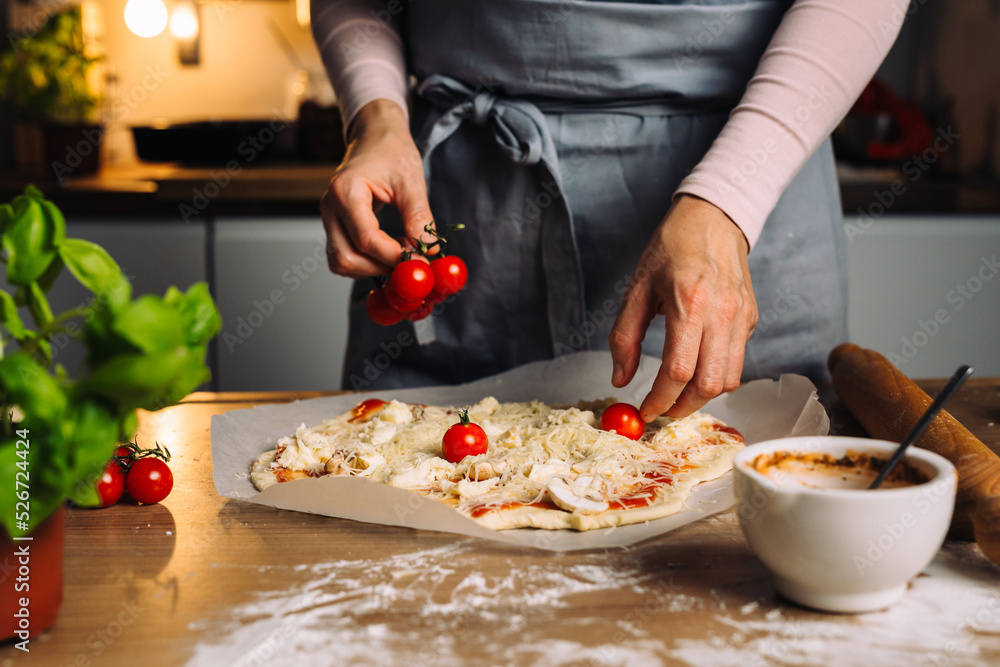 woman preparing homemade pizza in her kitchen