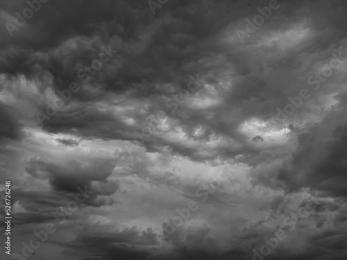 Black white sky with clouds. Dramatic cloudy sky background for design. Dark gray cloudscape. Wind before the storm. Ominous oppressive atmosphere.