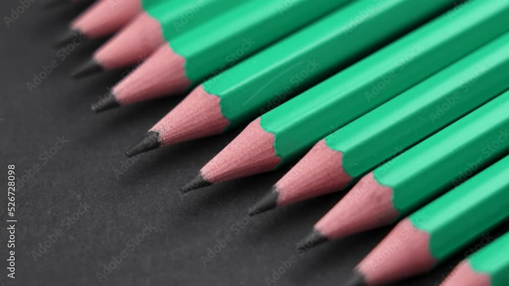 Sharpened wooden graphite pencils on a black background stacked in a row. School supplies art creative concept. Rotation Sharpened wooden graphite pencils on a black background stacked in a row. School supplies art creative concept. Rotation