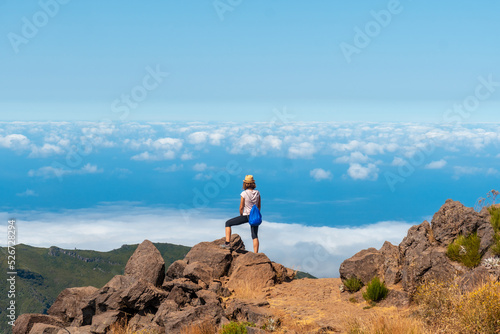 A young woman at the Miradouro do Juncal on Pico do Arieiro and its mountains  Madeira. Portugal