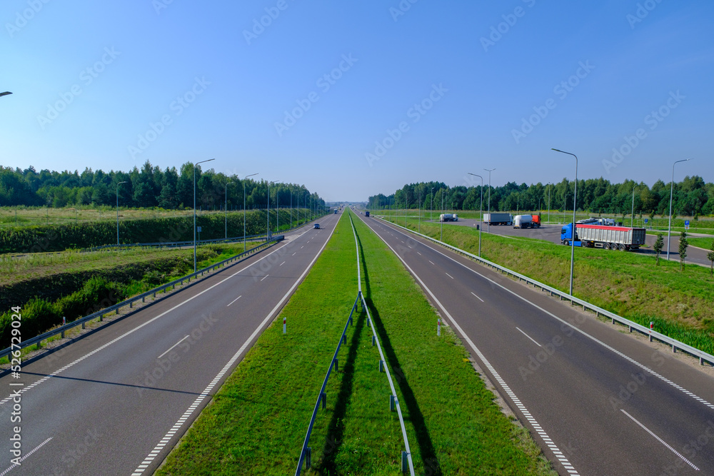 Expressway in several lanes S2 in Poland and a stop with several trucks. Summer August.