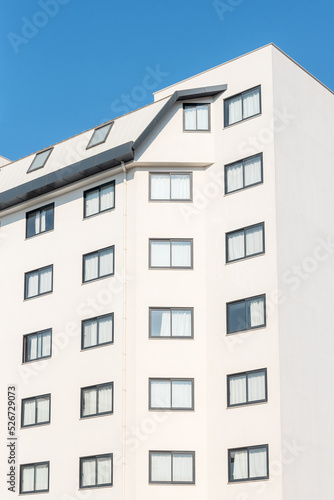 Close-up of the facade of a white building with windows.