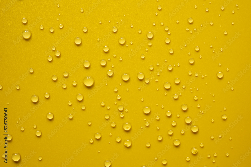 Lot of small drops on a yellow surface, splashed water. Abstract background. Top view. Lot of small drops on a yellow surface, splashed water. Abstract background. Top view.