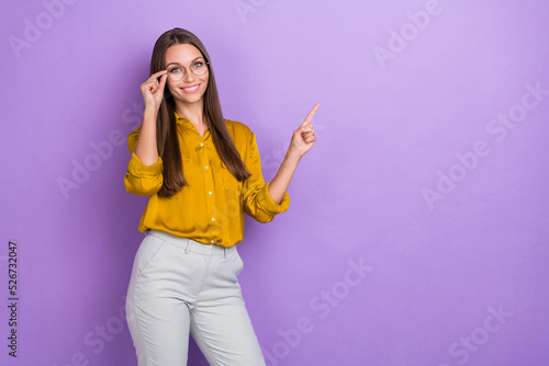 Portrait of positive pretty girl hand touch glasses indicate finger empty space isolated on purple color background