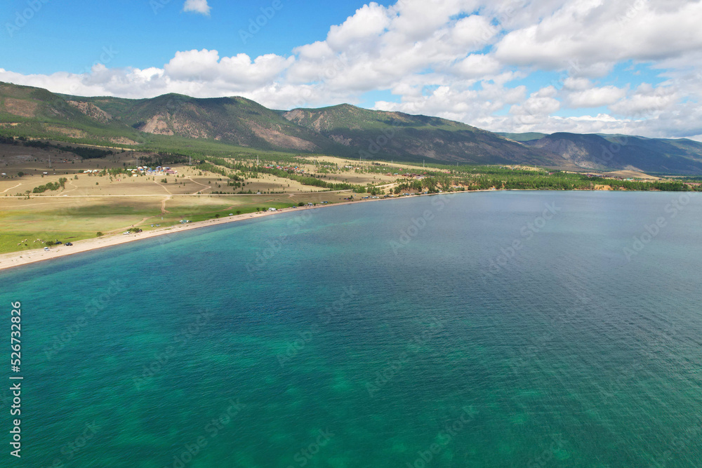 Lake Baikal from the air in summer. View of the Kurminsky Bay. Beautiful turquoise color of water, mountains