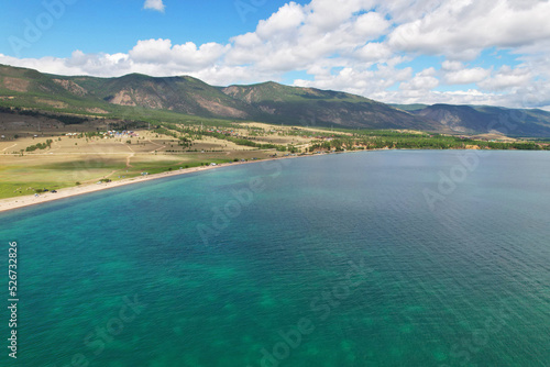Lake Baikal from the air in summer. View of the Kurminsky Bay. Beautiful turquoise color of water, mountains