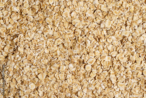 Rolled oat, oat flakes background or texture. Close up, directly above