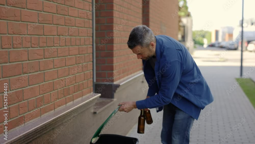 Portrait of the happy man going for a walk and holding two glasses bottles to sort them and put into the sorting bin. Ecology and environmental problems concept Portrait of the happy man going for a walk and holding two glasses bottles to sort them and put into the sorting bin. Ecology and environmental problems concept