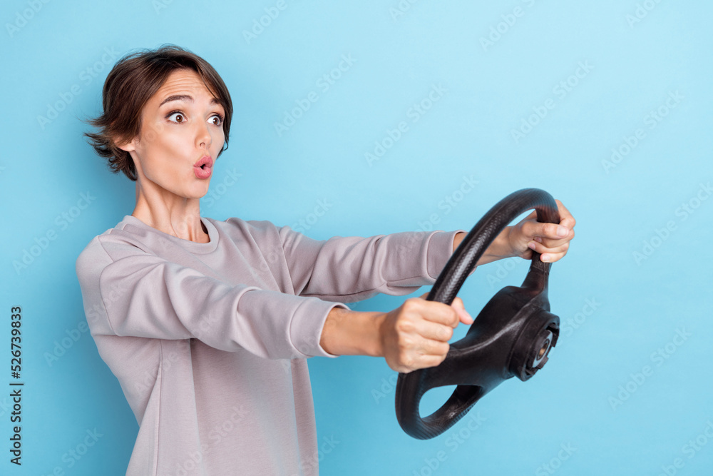 Photo of gorgeous staring woman with bob hairdo dressed gray pullover hold steering wheel accident crash isolated on blue color background Photo of gorgeous staring woman with bob hairdo dressed gray pullover hold steering wheel accident crash isolated on blue color background