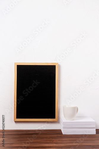 felt letter board hanging on the wall with stack of books and coffee cup
