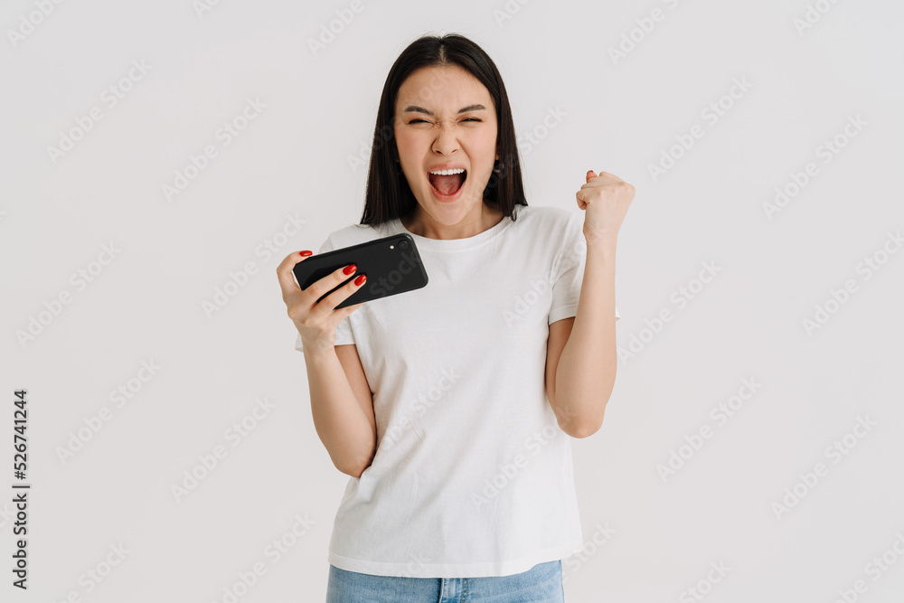 Asian excited woman playing video game on cellphone Asian excited woman playing video game on cellphone