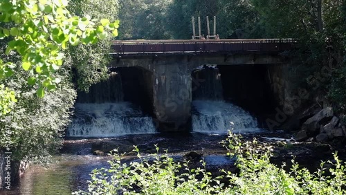 artificial waterfall from the dam under the bridge in the village of Perovo, Leningrad region photo