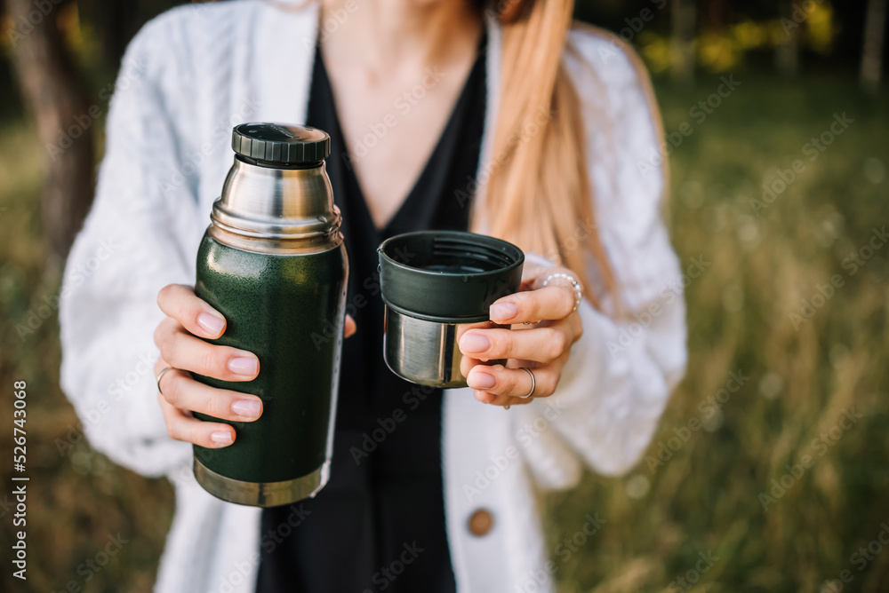 beautiful young girl with thermos is resting in nature beautiful young girl with thermos is resting in nature