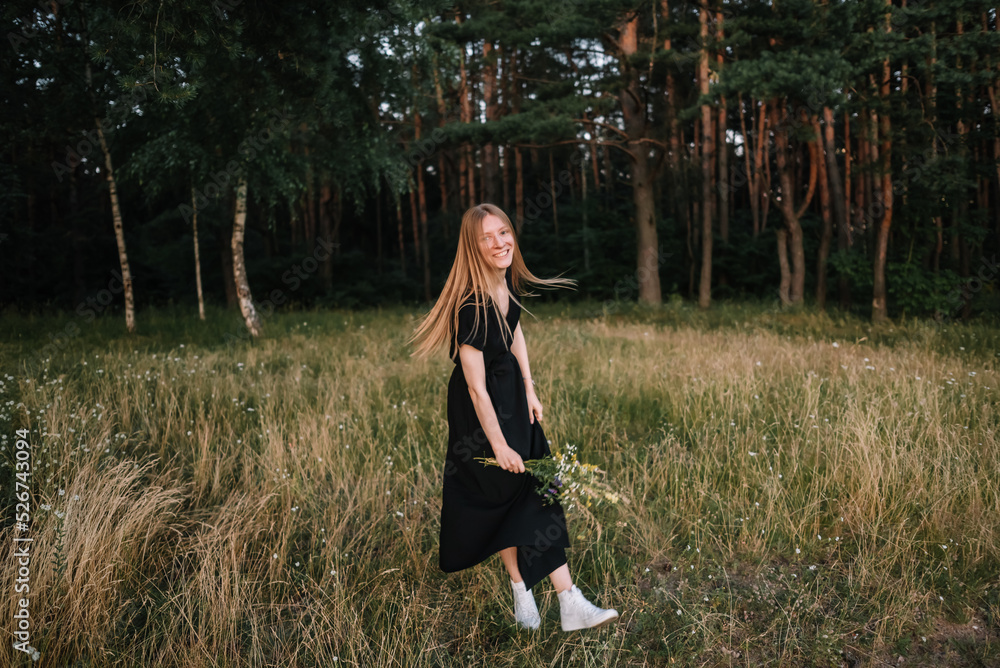 beautiful young girl in black dress and with long hair is resting in nature beautiful young girl in black dress and with long hair is resting in nature
